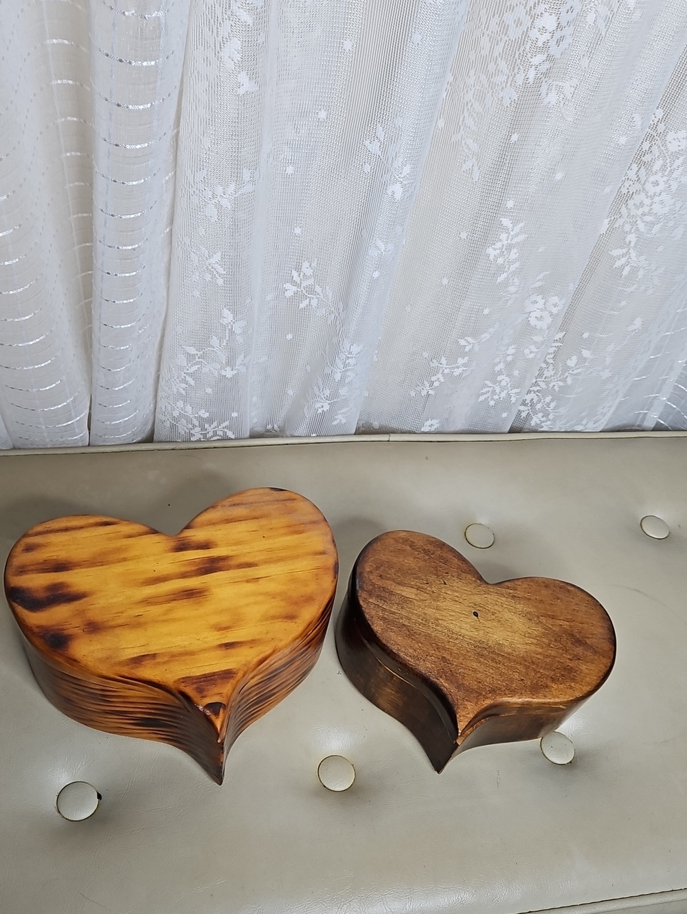 Two handmade, heart-shaped wooden boxes with visible grain patterns